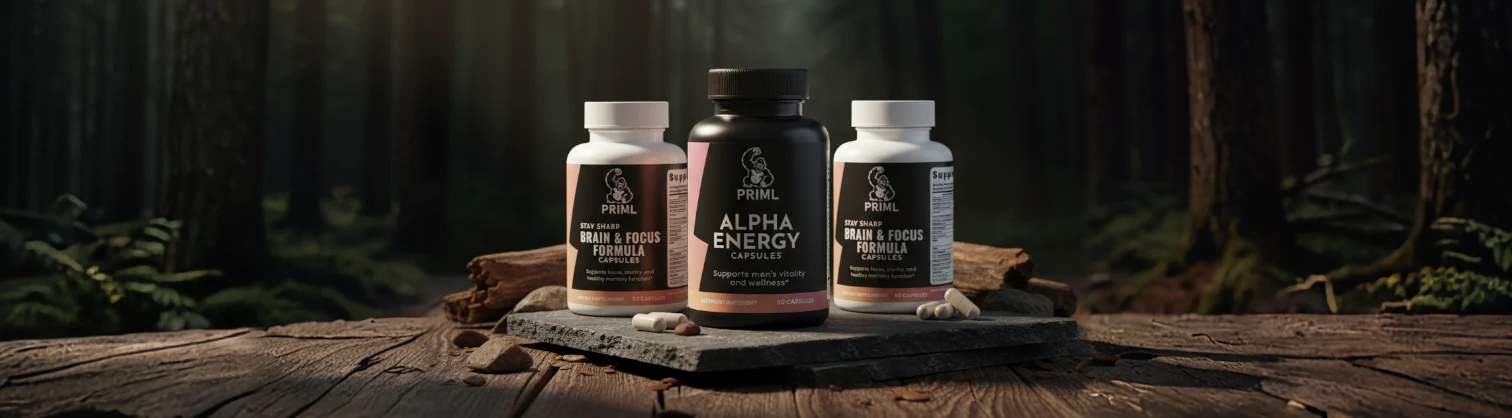Three bottles of Primal supplements, including Alpha Energy Capsules and Brain & Focus Formula, are displayed on a stone slab in a forest setting.